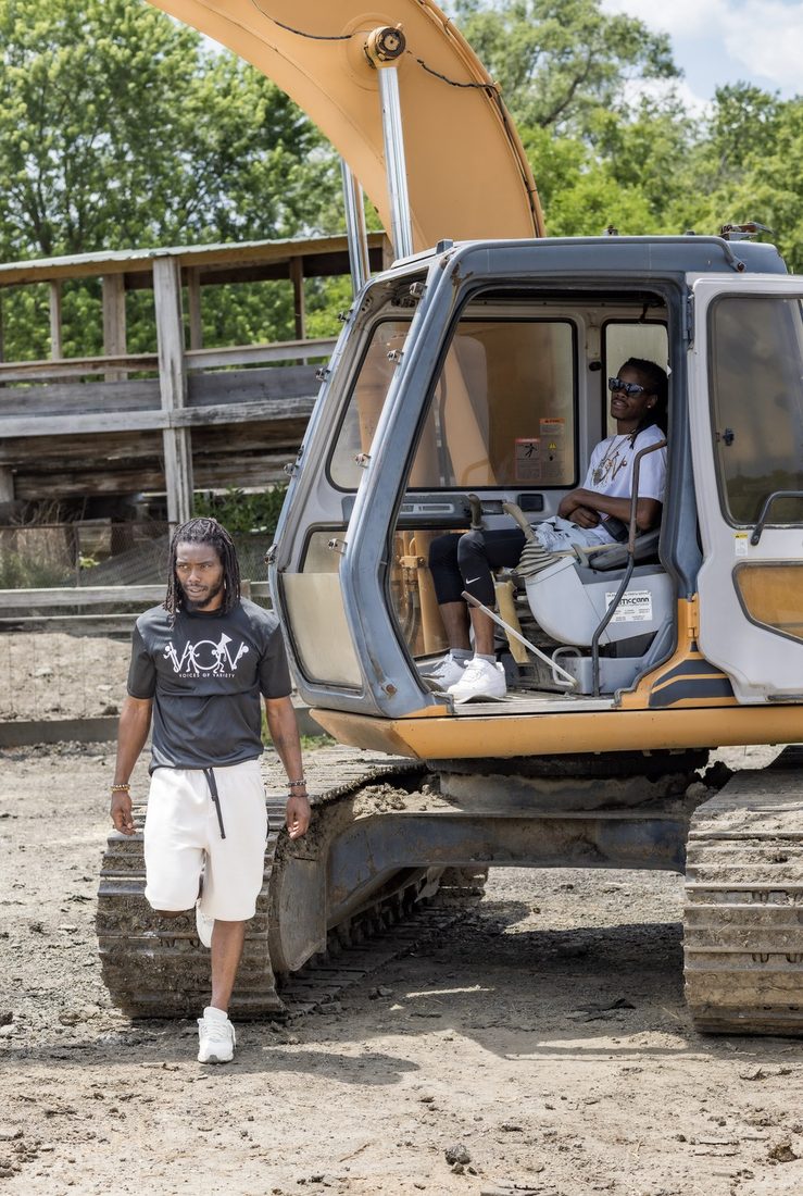 Two V.O.V members with a full-size excavator on a job site