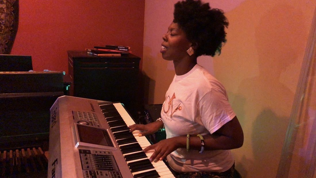A V.O.V vocalist singing at the keyboard in the studio