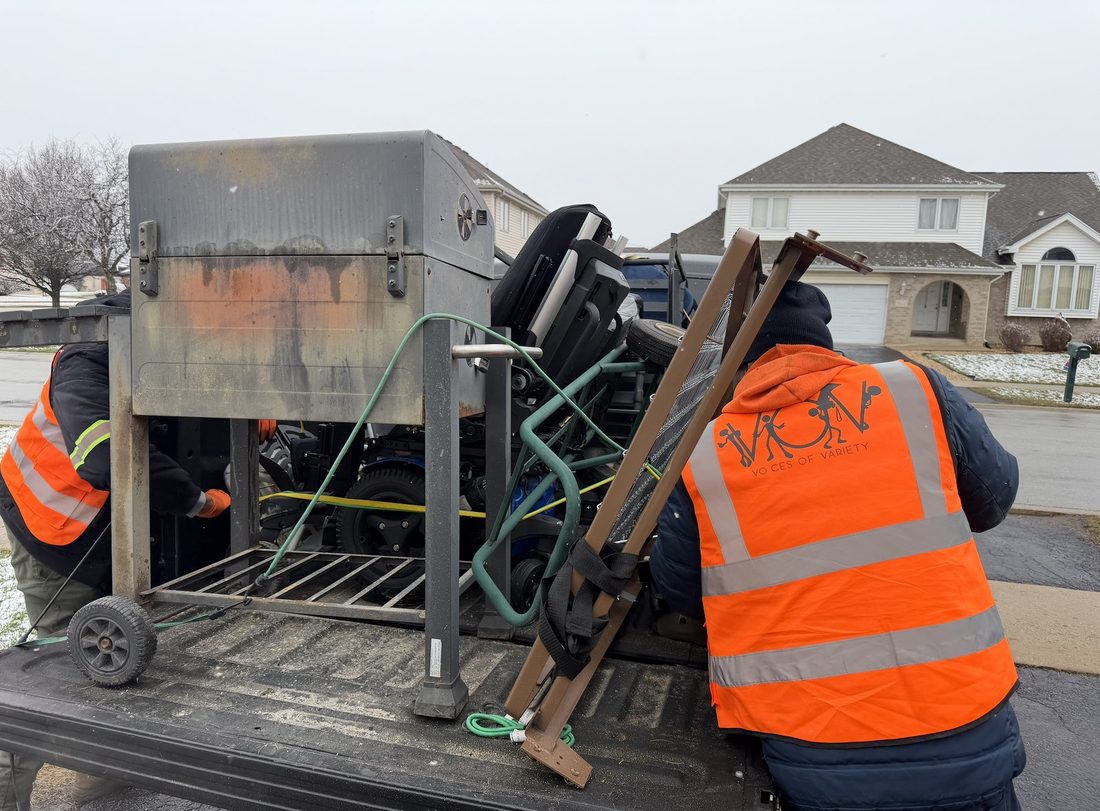 V.O.V crew in safety vests hauling away heavy items for a neighbor