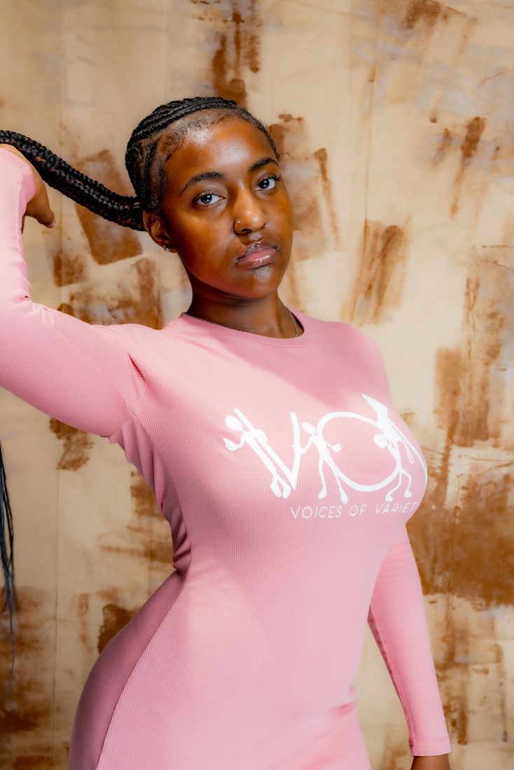 Model in the pink V.O.V long sleeve dress with white logo