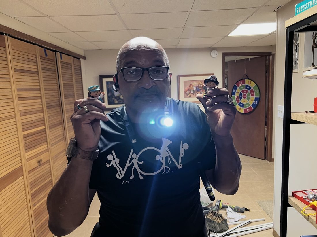 A V.O.V member holding toy figures with a flashlight