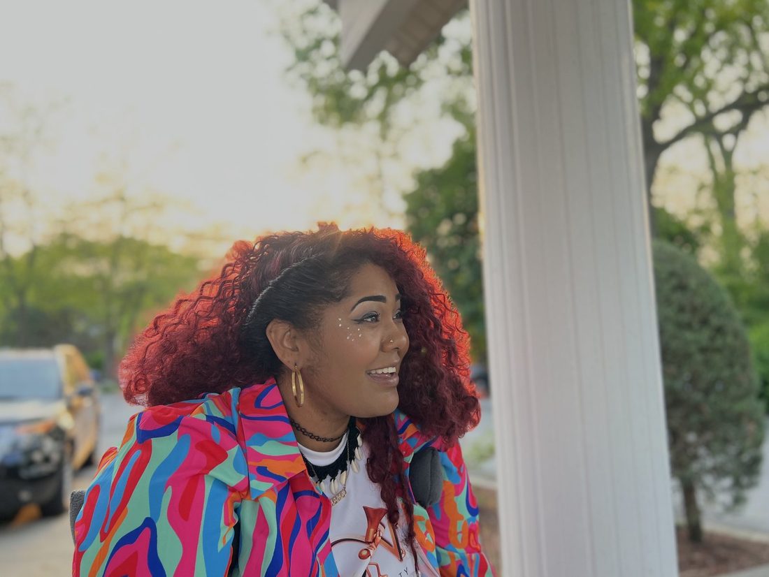 A V.O.V member smiling in her colorful jacket