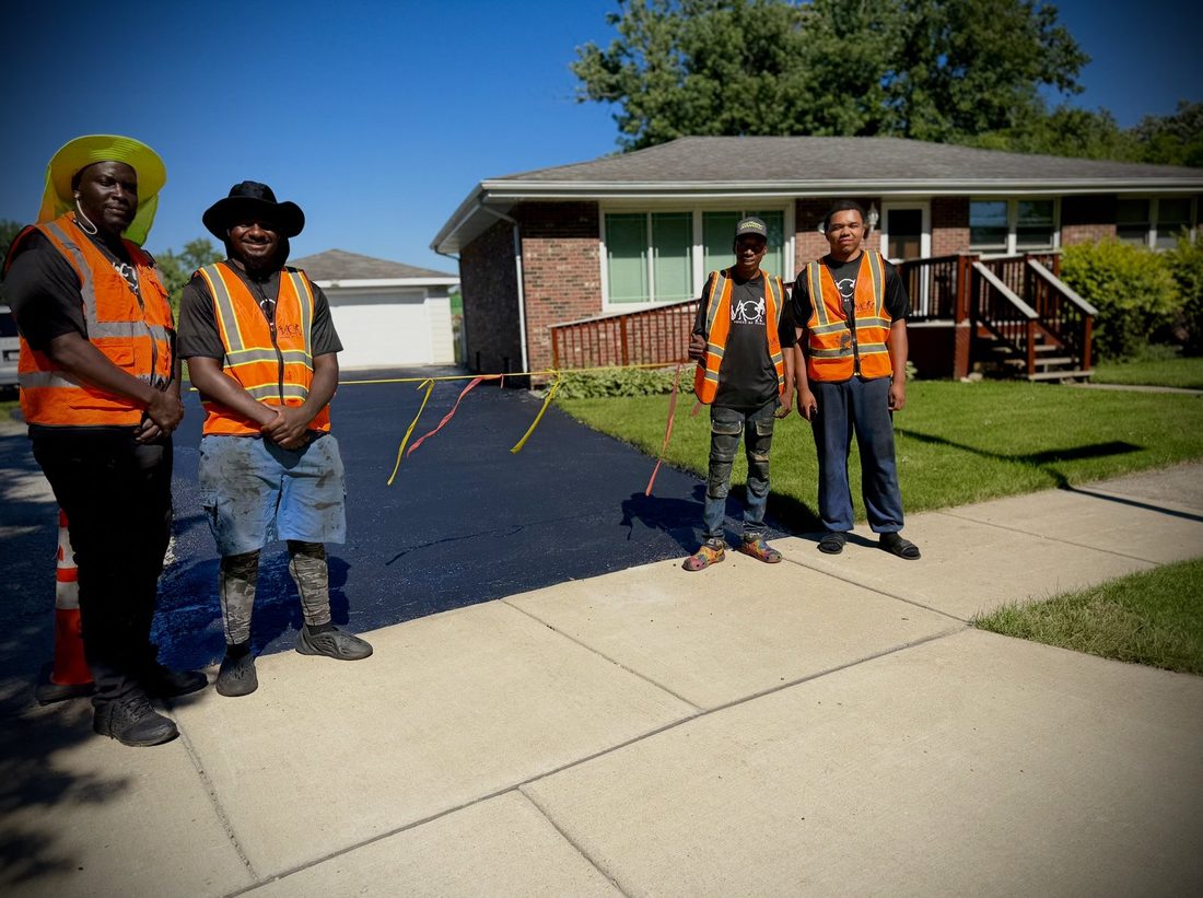 Four V.O.V crew members by a completed driveway job
