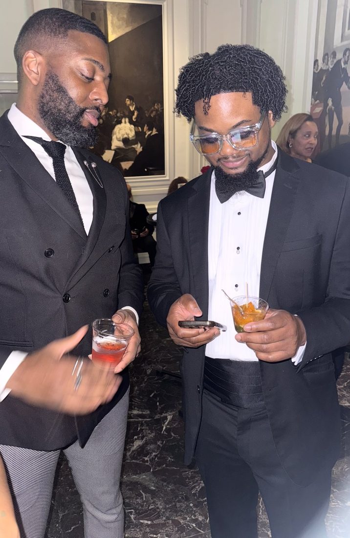 Two V.O.V members in tuxedos networking at the gala