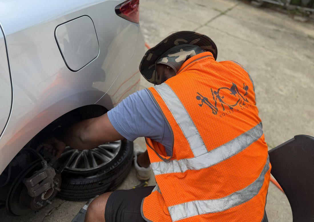 A V.O.V member changing a tire in the orange vest