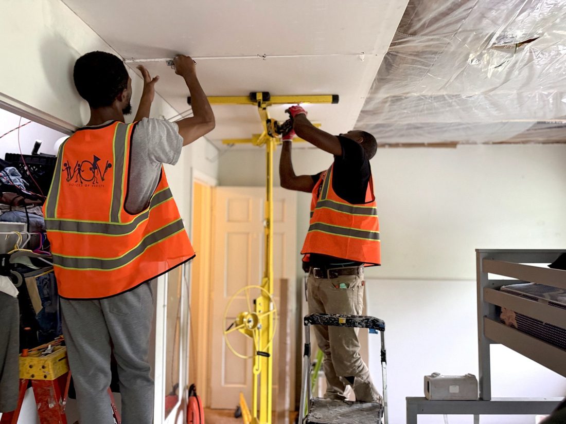 V.O.V workforce crew installing a ceiling with a drywall lift